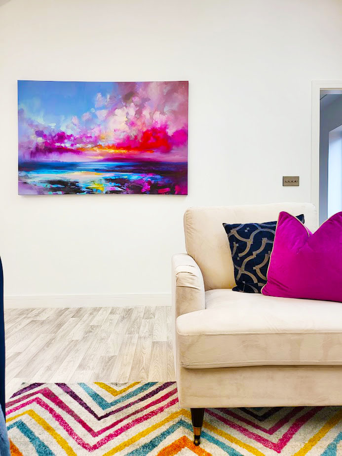 Property Staging For Sale in Worcestershire. Image showing a contemporary home with neutral coloured armchair with purple and navy cushions set on a colourful area rug