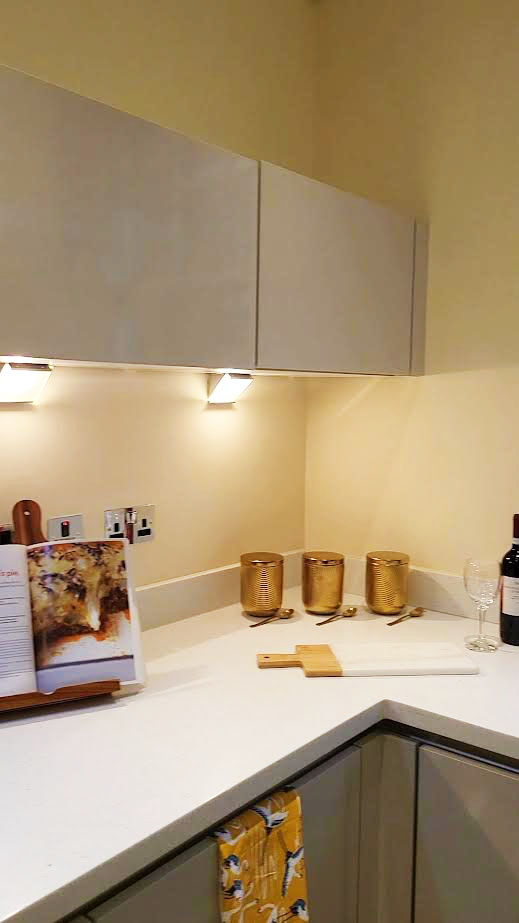 Image of a kitchen that has been staged for sale with use of ambient lighting and gold accessories